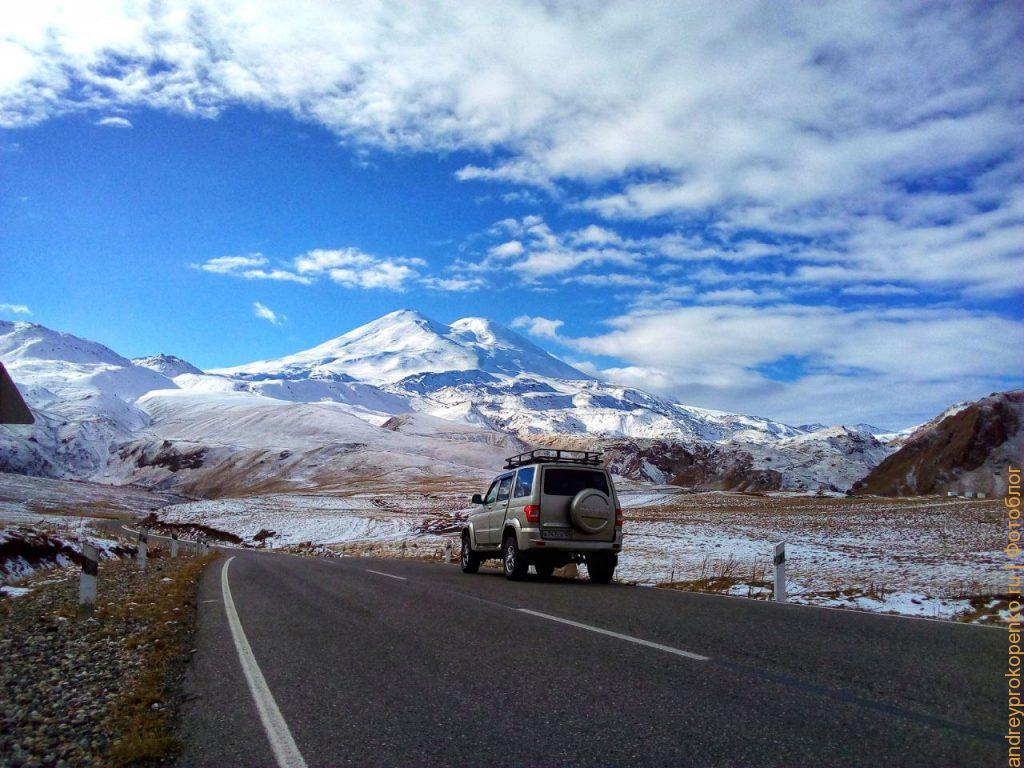 Машина (внедорожник) на фоне горы Эльбрус едет в джип-тур
