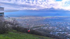 Красный вагончик канатной дороги отъезжает с верхней станции канатной дороги на горе Машук в Пятигорске